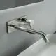 Wand-Waschtischarmatur in Silber von Ideal Standard mit eckiger Rosette und einem geraden Auslauf, montiert an einer hellen Wandoberfläche.